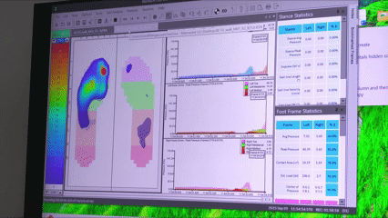 A plantar pressure test on a large television screen, showing underfoot pressure on a subject in the INSITE Research & Design Lab